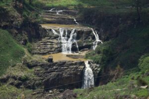 A picturesque waterfall cascading through rocky terrain in Nuwara Eliya, Sri Lanka.