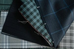 Detailed close-up of assorted plaid and checkered fabrics, showcasing textile textures and patterns.